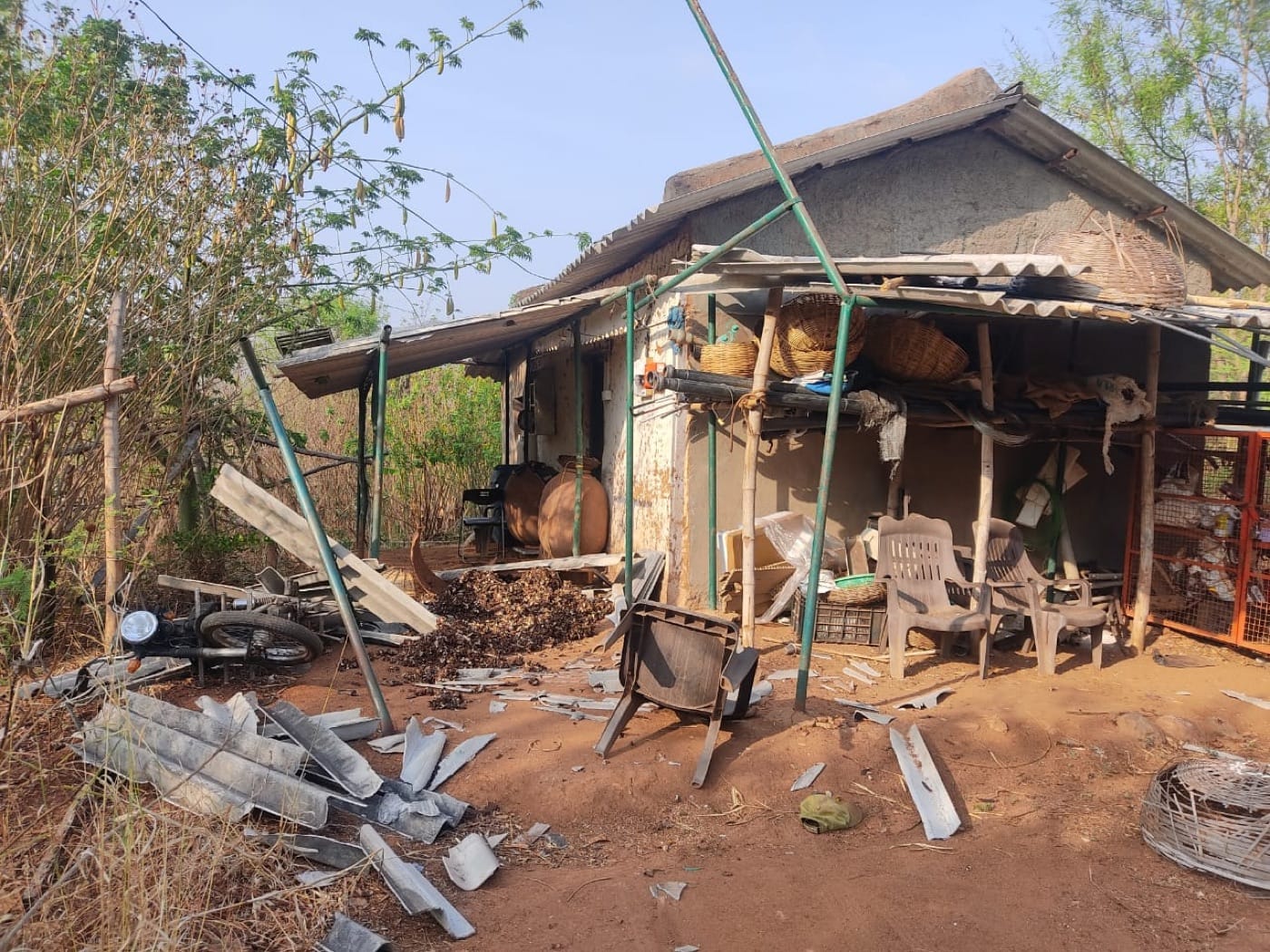 An elephant damaged structures near the mud hut while foraging for food.