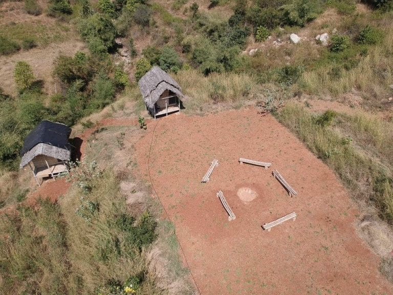 Aerial view of TVC's camping huts and firepit clearing on the hillside